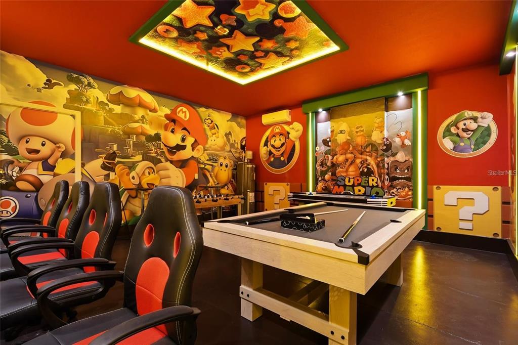 A Super Mario-themed game room features a pool table, gaming chairs, and wall murals — 3083 MAHALO DRIVE, DAVENPORT, FL