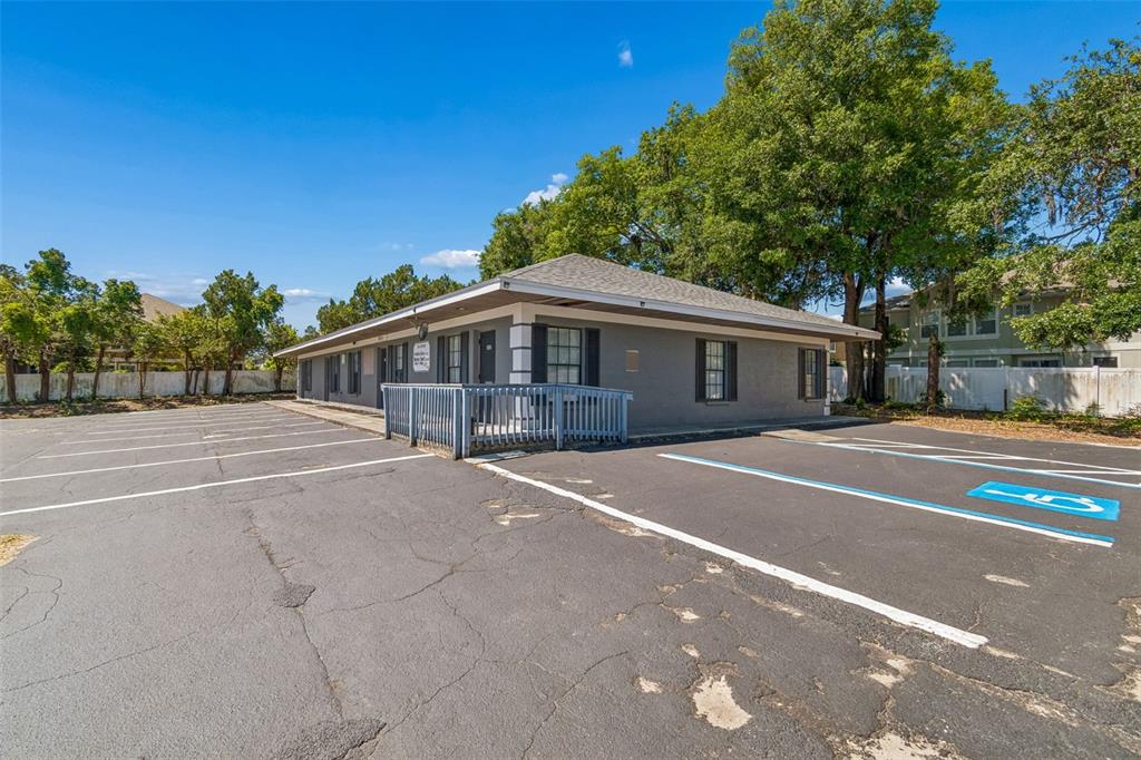 A single-story gray commercial building features a parking lot with a designated handicap space — 7511 LITTLE ROAD, NEW PORT RICHEY, FL