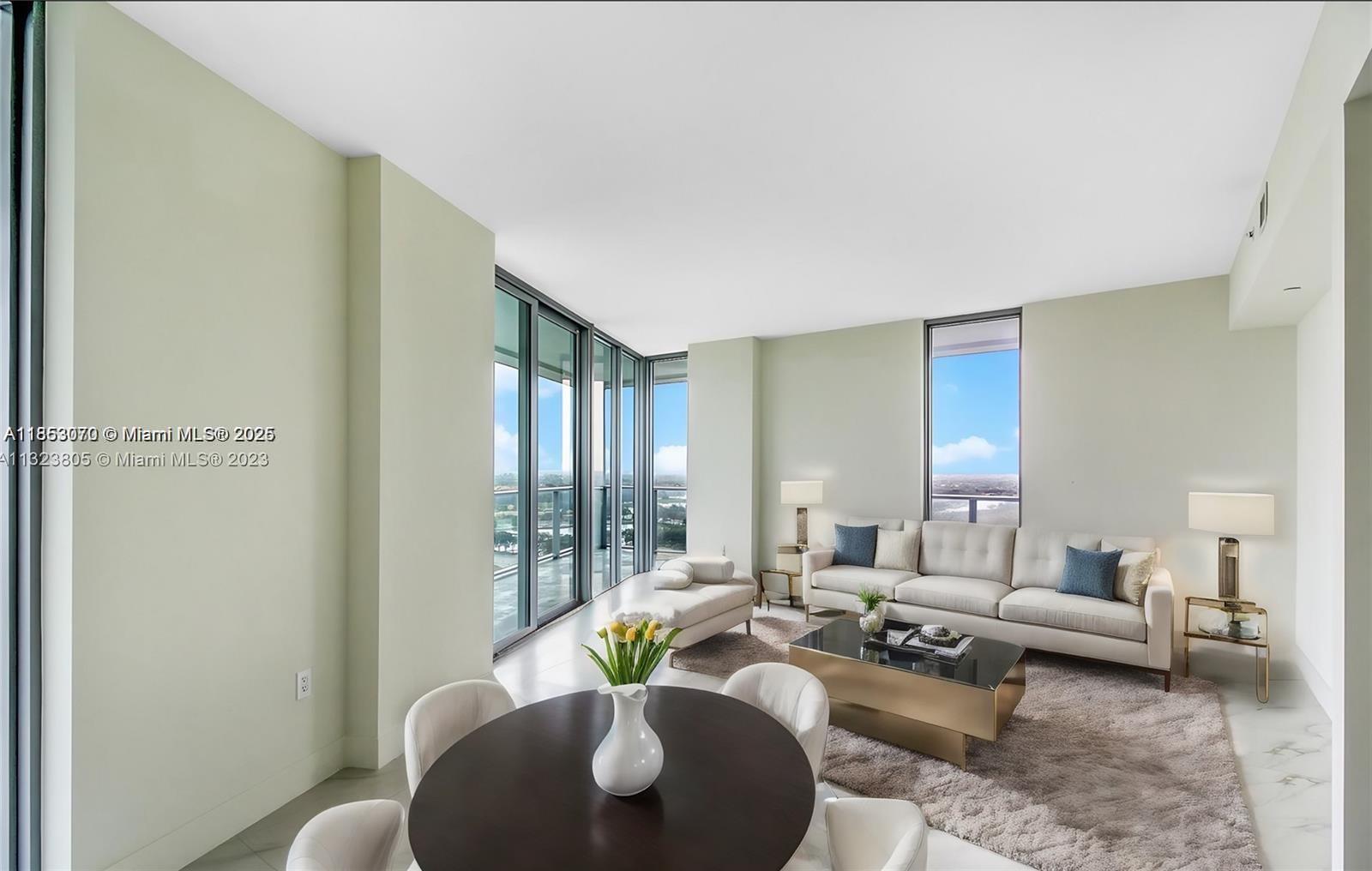 A living and dining area features floor-to-ceiling windows, light walls, and marble-style flooring — 2000 Metropica Way # 1709, Sunrise FL 33323, SUNRISE, FL
