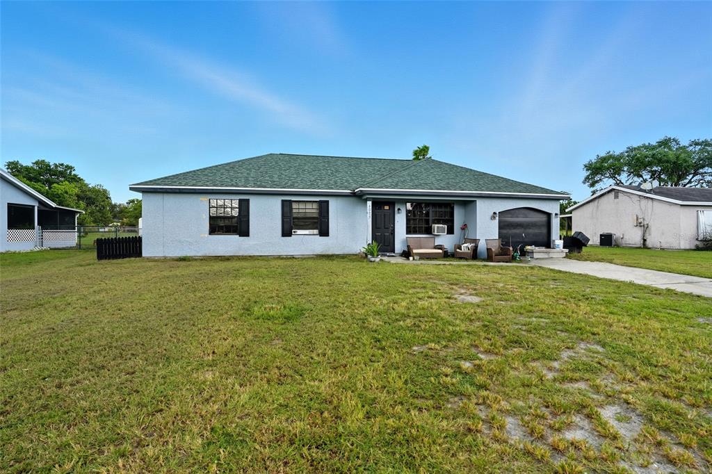 A single-story house with a green roof, light blue exterior, and an attached garage — 4005 W SUNFLOWER CIRCLE, LABELLE, FL