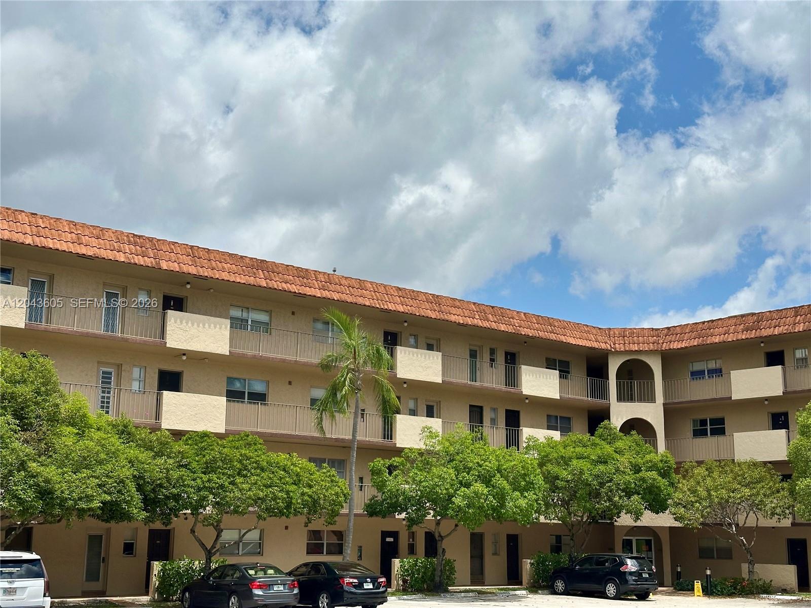A three-story apartment building with a terracotta tile roof and a parking lot — 6201 N Falls Cir Dr # 212, Lauderhill FL 33319, LAUDERHILL, FL
