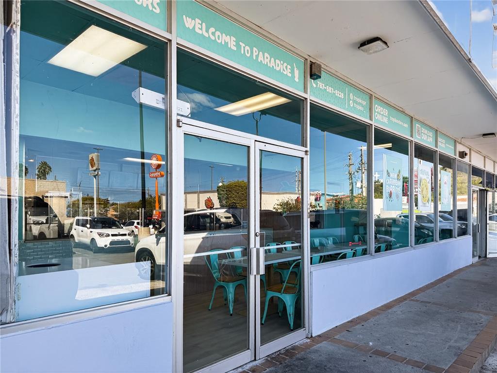 The exterior of a commercial storefront features large glass windows and a central glass door — Calle 24 URB SIERRA BAYAMON, BAYAMON, PR