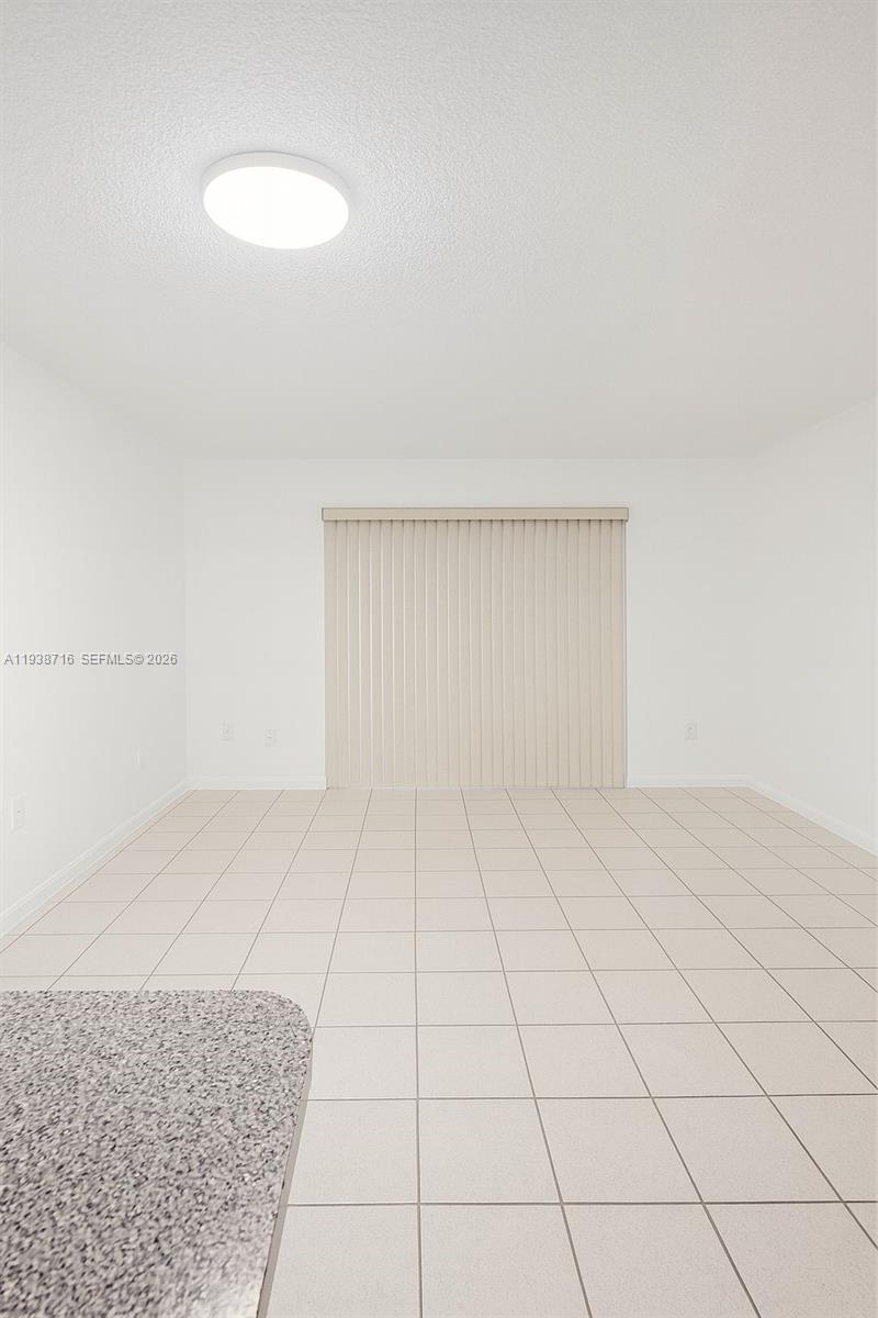 A room with white walls, light-colored floor tiles, a ceiling light, and vertical window blinds — 8170 NW 10th St # 2, Miami FL 33126, MIAMI, FL