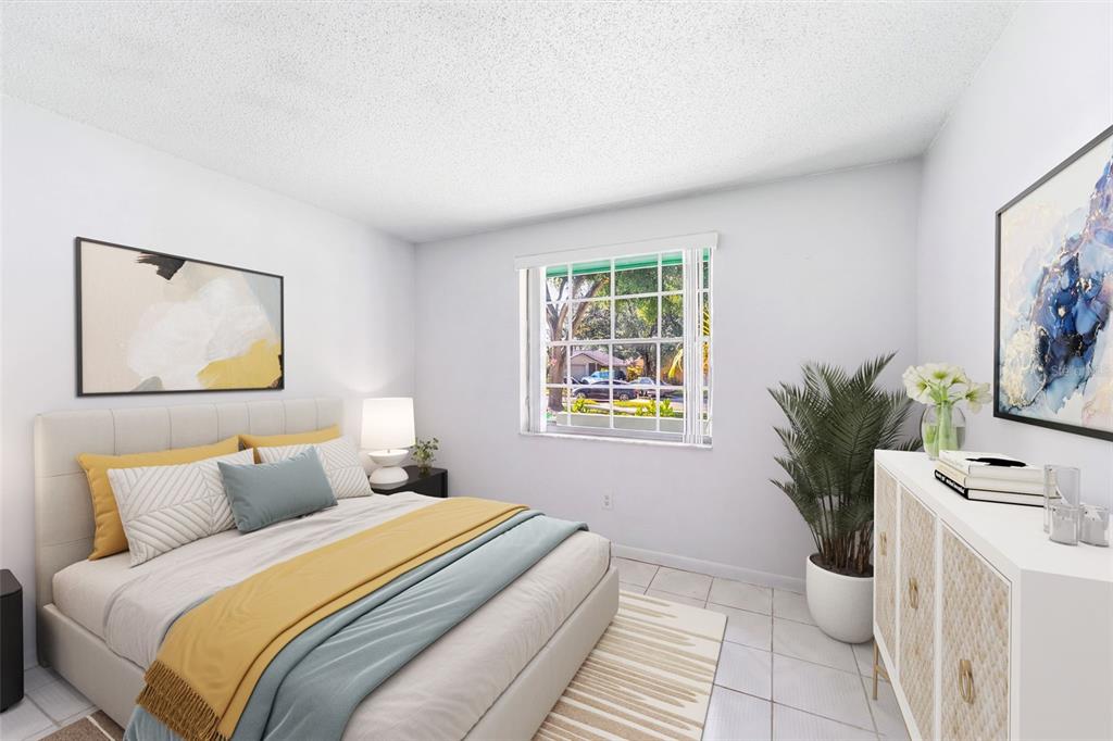 A bedroom features a bed with yellow and blue bedding, a window, and white furniture — 12614 LOGAN PLACE, TAMPA, FL