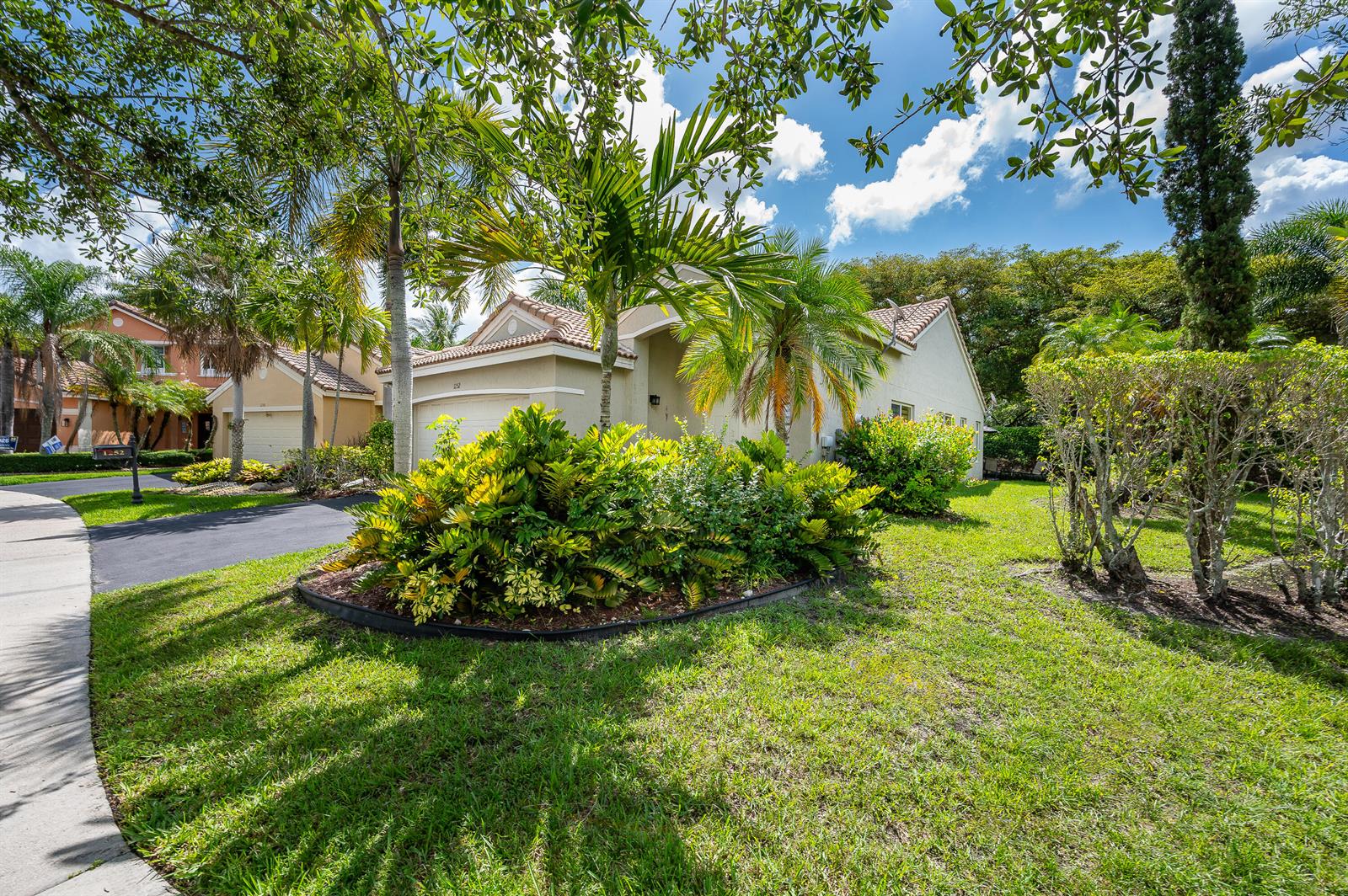 A single-story house with a beige exterior, a tiled roof, and a landscaped front yard — 1252 Sabal Trail, Weston FL 33327, WESTON, FL