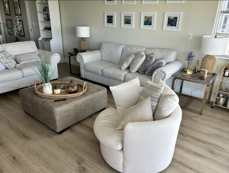 A living room features two light-colored sofas, a large ottoman, and a round swivel chair — 3520 Oaks Way # 607, Pompano Beach FL 33069, POMPANO BEACH, FL