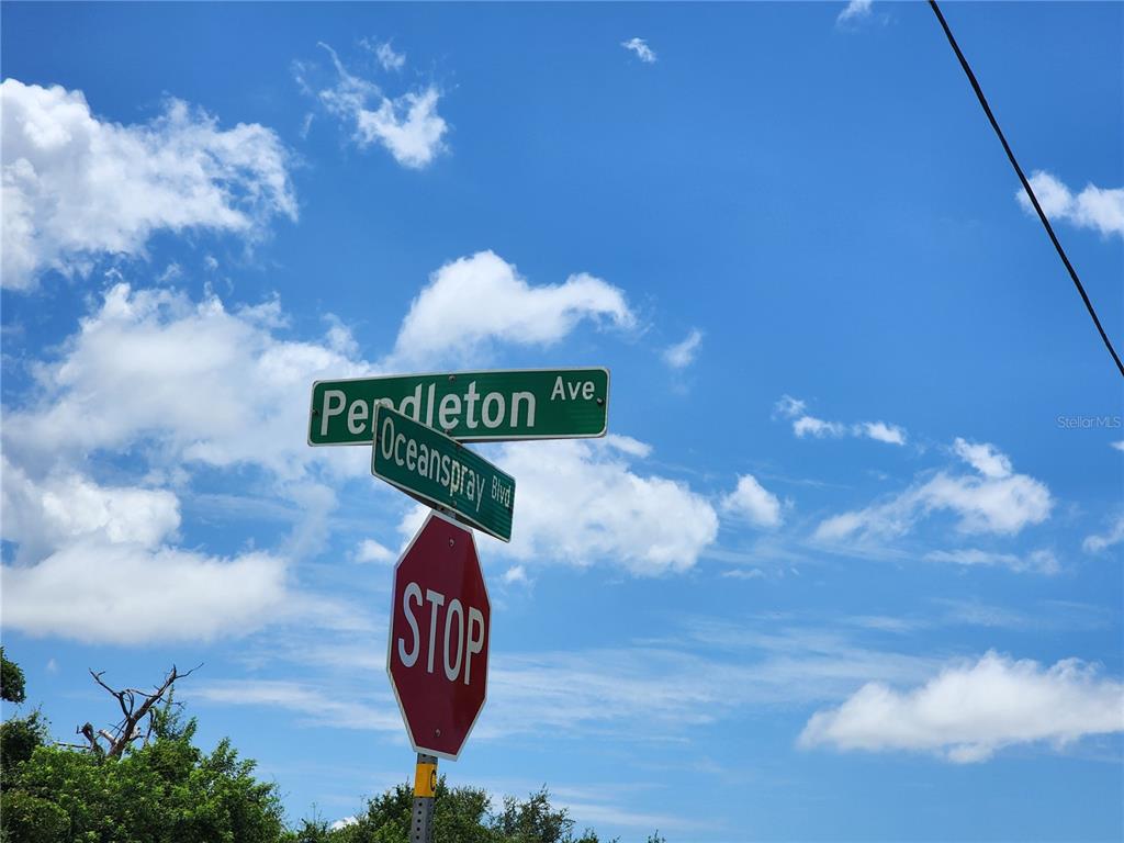 A street sign for Pendleton Ave and Oceanspray Blvd stands above a stop sign — 11256 PENDLETON AVENUE, ENGLEWOOD, FL