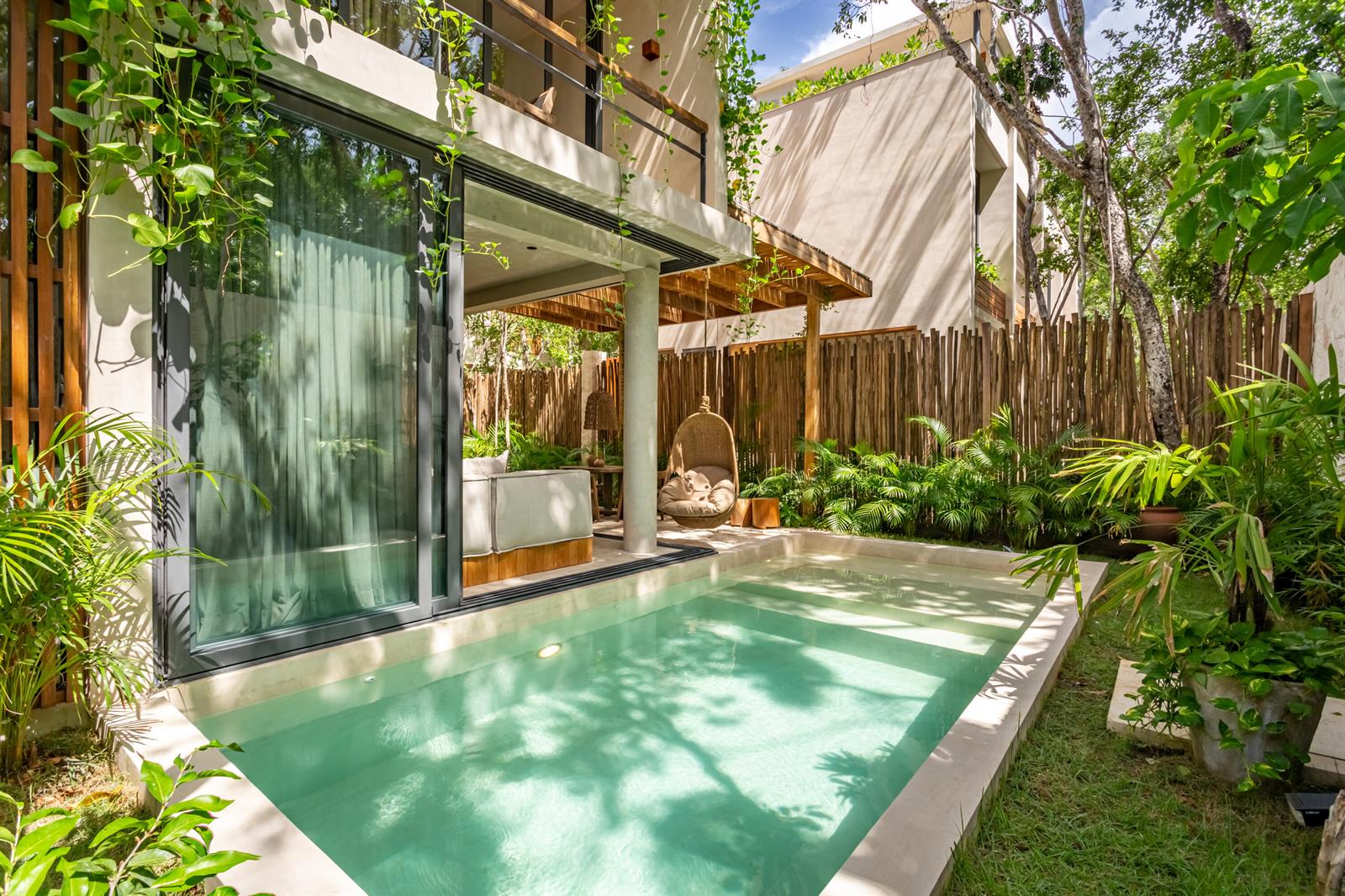A modern villa features a private swimming pool, a hanging chair, and lush tropical landscaping — Amari Tulum , 10 Avenida Norte & Calle Palma Unit 8k, FL