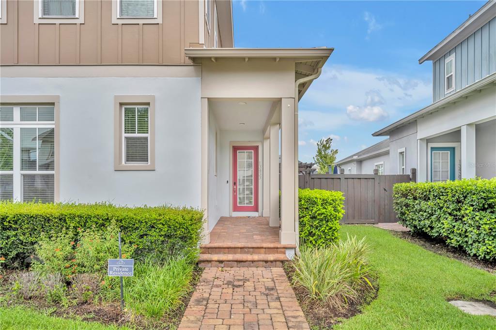 A brick walkway leads to the covered front porch of a two-story home — 13433 STODDART AVENUE, ORLANDO, FL