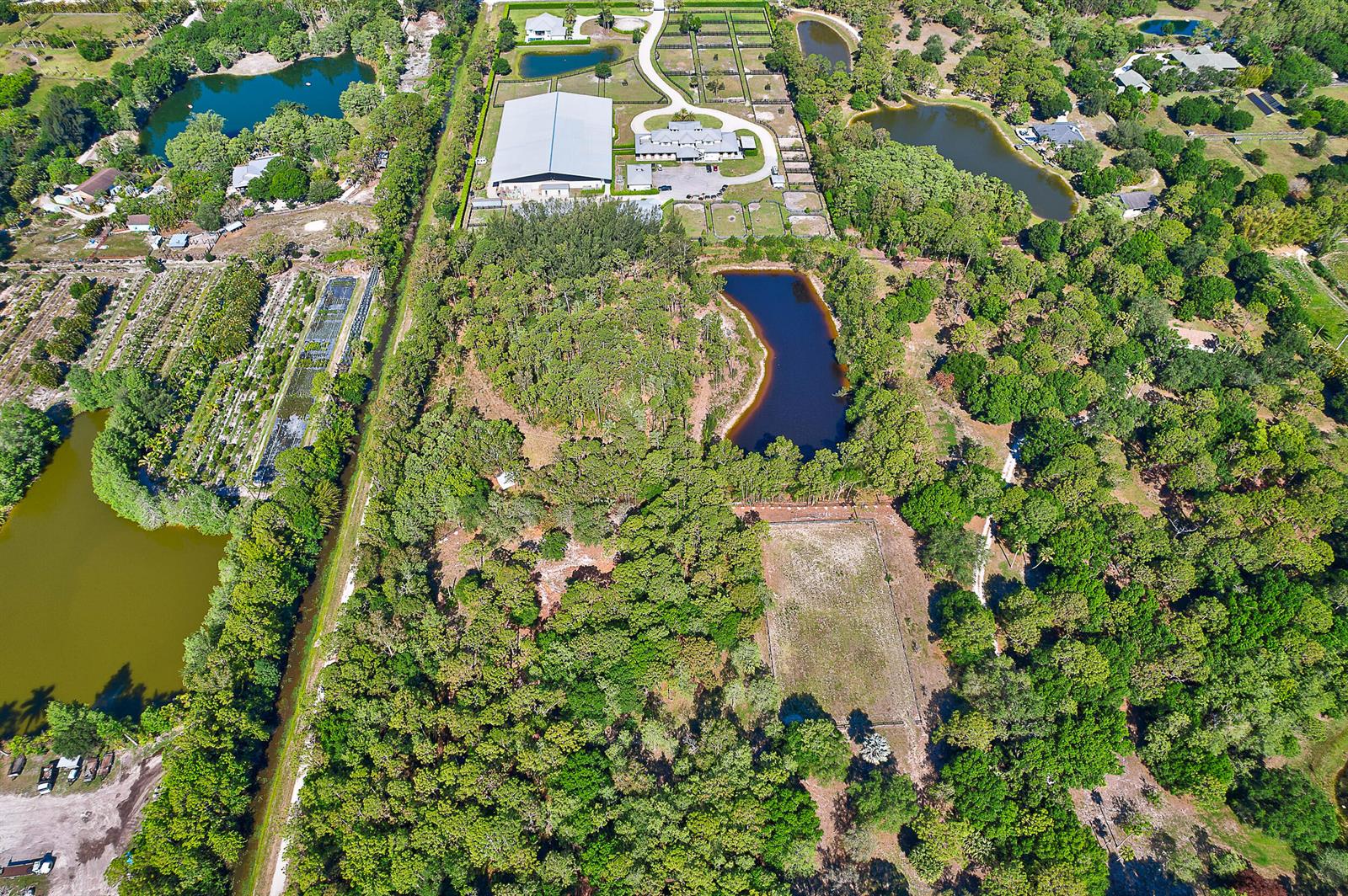 An aerial view shows a large rural property featuring multiple ponds, wooded areas, and buildings — 18395 131st Trail N, Jupiter FL 33478, JUPITER, FL