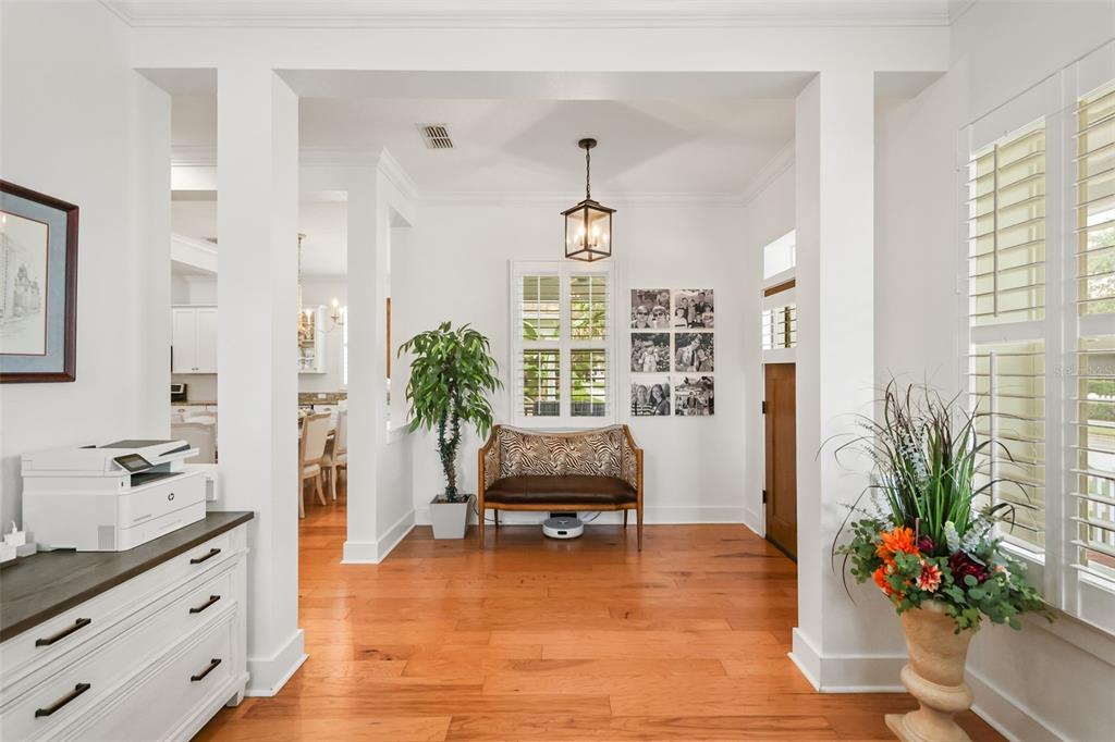 A bright entryway features hardwood floors, a wooden bench, a hanging lantern, and white walls — 925 EASLEY AVENUE, WINTER GARDEN, FL