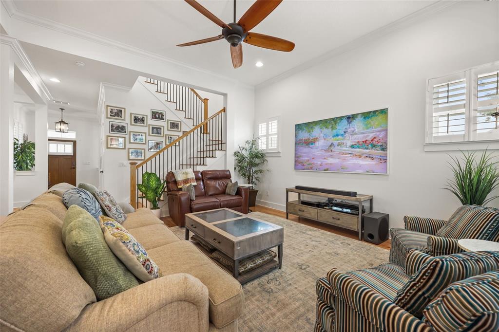 A living room features a beige sofa, striped armchairs, a leather loveseat, and a staircase — 925 EASLEY AVENUE, WINTER GARDEN, FL