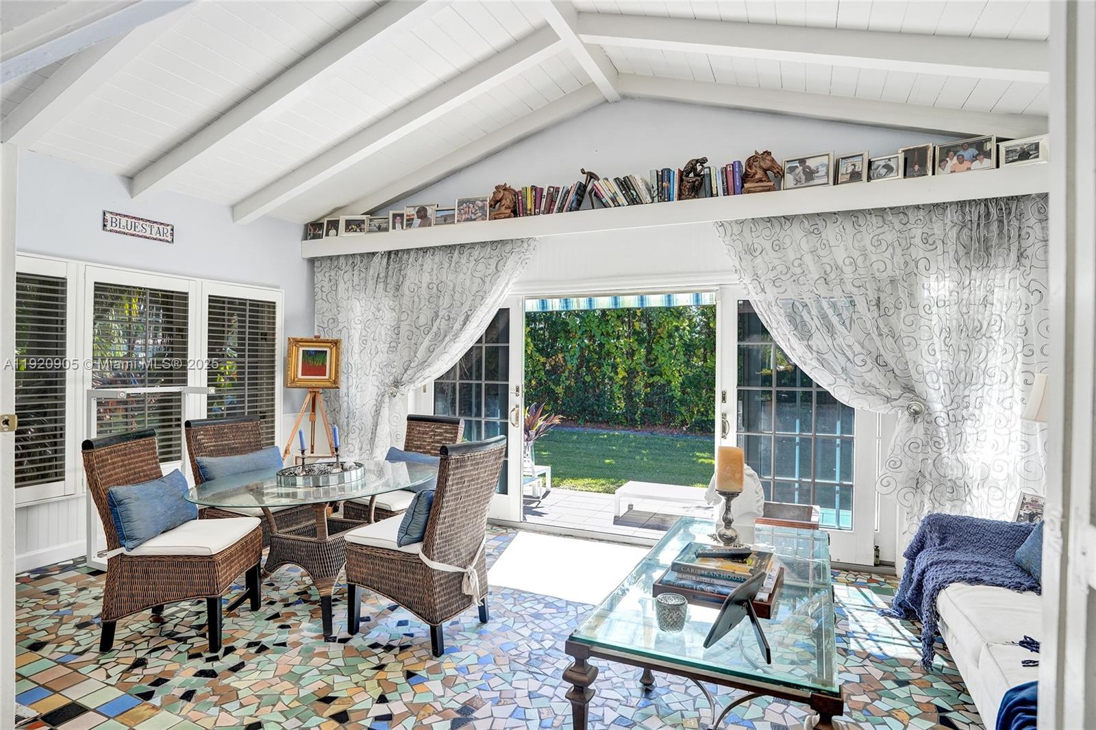 A sunroom features a mosaic tile floor, vaulted ceiling, and sliding glass doors to a yard — 940 Hollywood Blvd, Hollywood FL 33019, HOLLYWOOD, FL