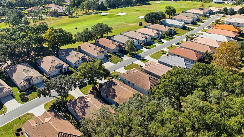 An aerial view shows a suburban neighborhood with houses bordering a golf course — 389 W DOERR PATH, HERNANDO, FL