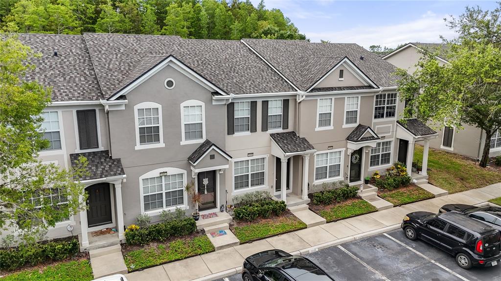 An exterior view of a multi-unit townhouse complex with gray siding and a parking lot — 10445 WESTPARK PRESERVE BOULEVARD, TAMPA, FL