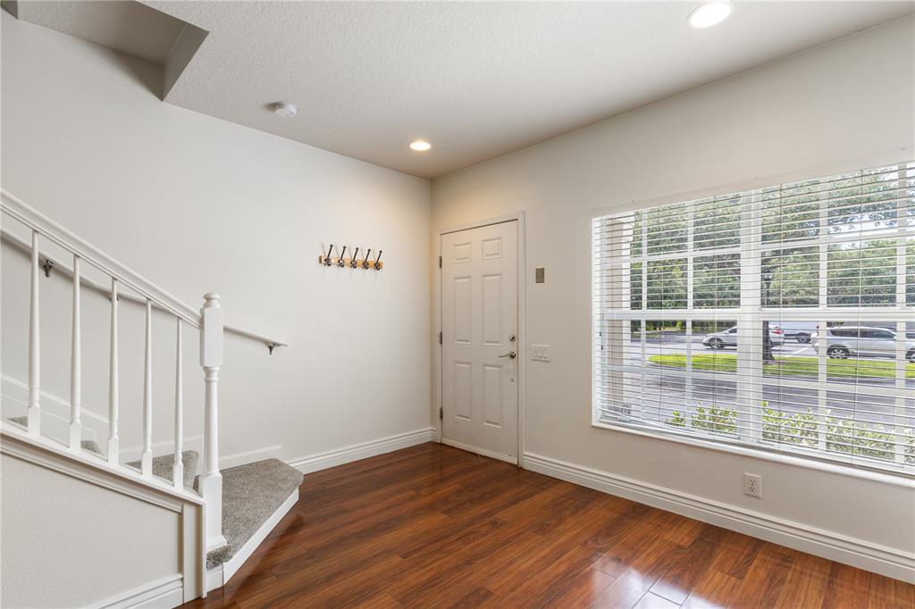 An entryway features hardwood flooring, a carpeted staircase with white railings, and a large window — 10445 WESTPARK PRESERVE BOULEVARD, TAMPA, FL
