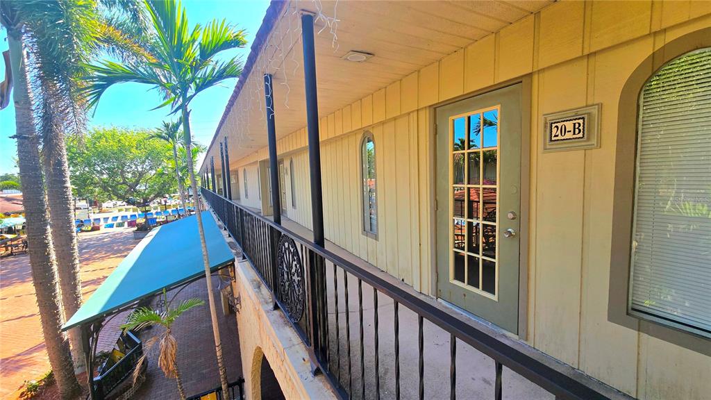 An exterior walkway with a black metal railing leads to a door marked 20-B — 530 US-41-BYP UNIT 20-21B, VENICE, FL