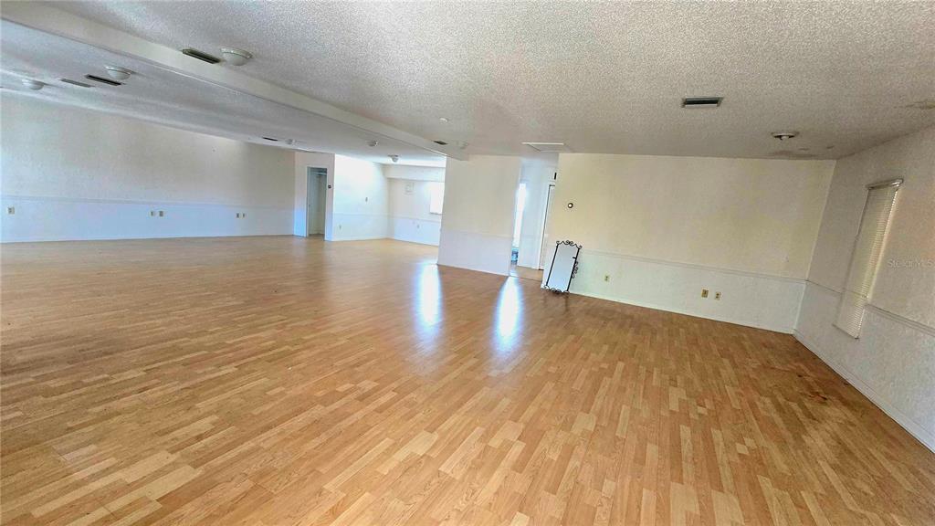 An expansive, empty room features light wood-look flooring, white walls, and recessed ceiling lighting — 530 US-41-BYP UNIT 20-21B, VENICE, FL