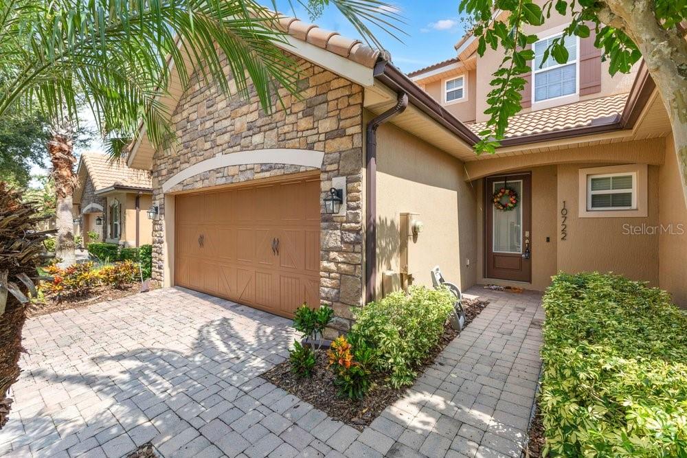 A single-story house exterior features a stone-faced garage, a paved driveway, and a front entryway — 10722 BELFRY CIRCLE, ORLANDO, FL