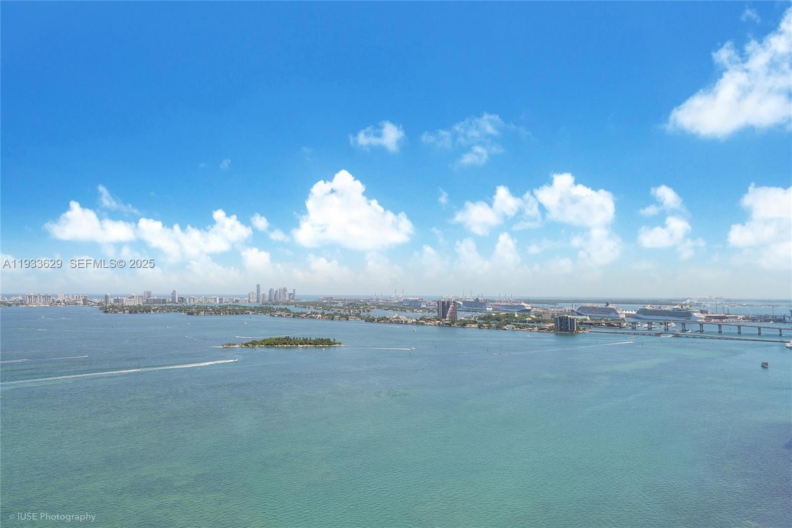 An aerial view shows a bay with a small island, distant city skyline, and cruise ships — 2900 NE 7th Ave # 3108, Miami FL 33137, MIAMI, FL