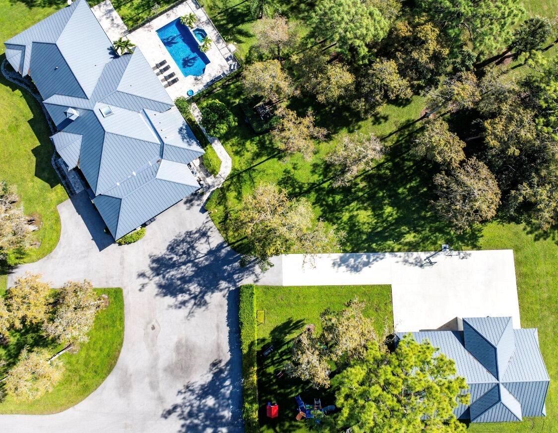 An aerial view shows a house with a metal roof, a pool, and a detached garage — 11230 Alligator Trail, Lake Worth FL 33449, LAKE WORTH, FL