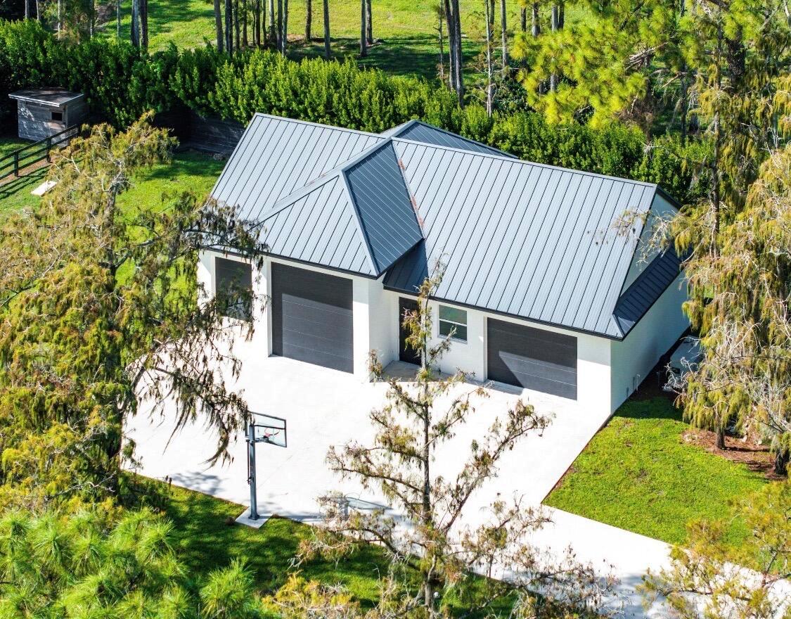 An aerial view of a white detached garage with a dark metal roof and driveway — 11230 Alligator Trail, Lake Worth FL 33449, LAKE WORTH, FL