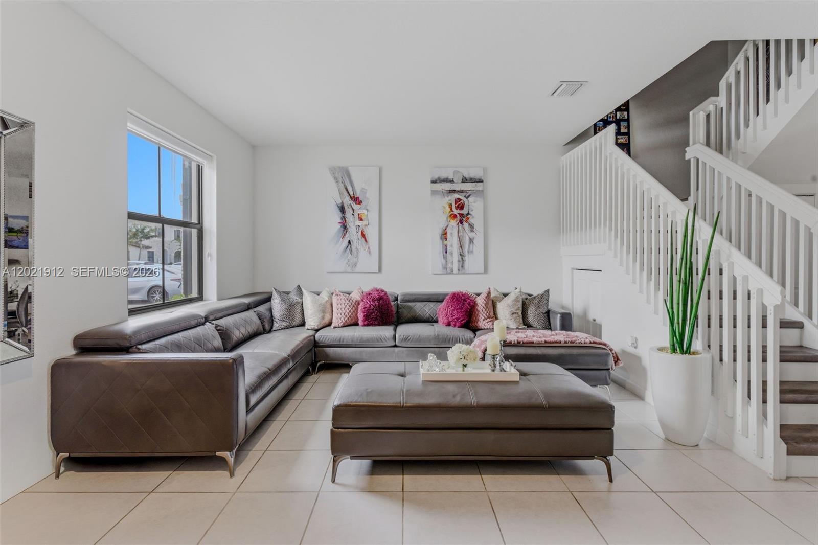 A living room features a large gray sectional sofa, a matching ottoman, and a staircase — 10009 SW 228th Ter, Miami FL 33190, MIAMI, FL