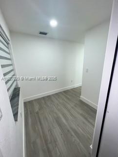 A small, empty room features light-colored wood-look flooring, white walls, and a window with blinds — 972 N 18th Ct, Hollywood FL 33020, HOLLYWOOD, FL