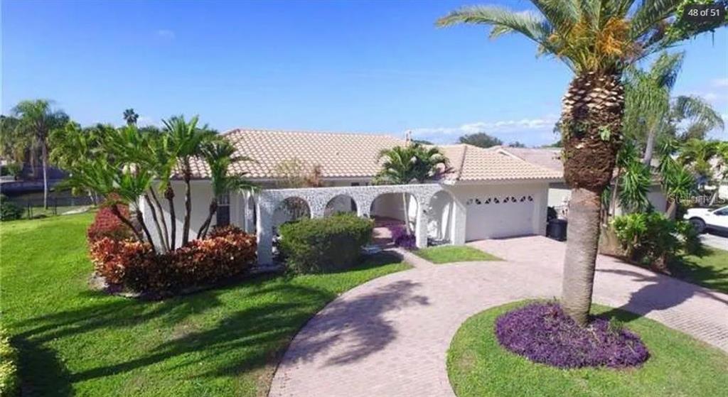 A single-story house with a tiled roof, arched entryway, and a paved circular driveway — 2001 HAWAII AVENUE NE, ST PETERSBURG, FL