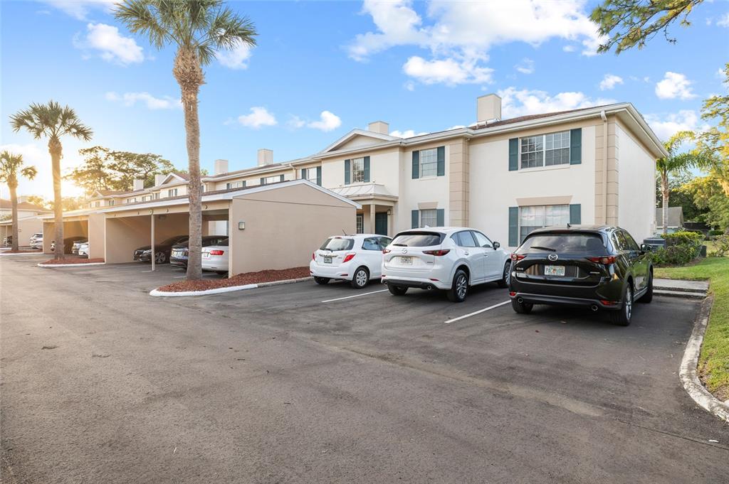 A two-story apartment building with a covered parking area and several parked cars — 3402 LATANIA DRIVE UNIT 321, TAMPA, FL