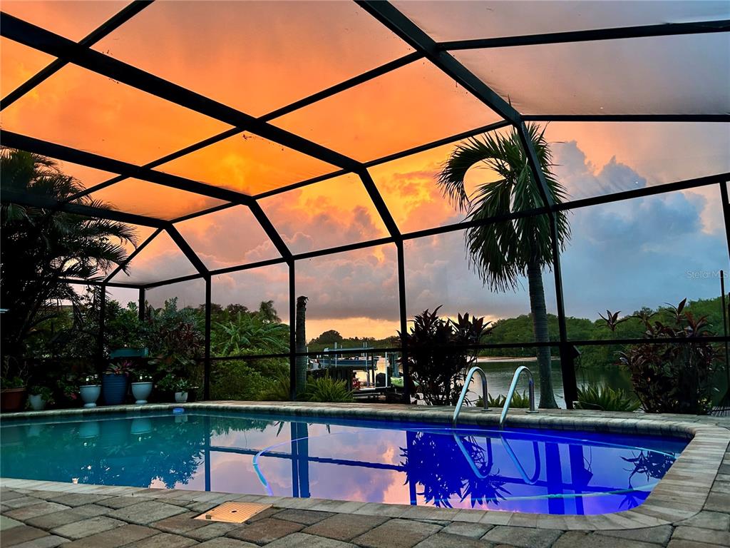 A single-story house with a white exterior and red roof sits behind a grassy lawn — 2126 EGRET DRIVE, CLEARWATER, FL