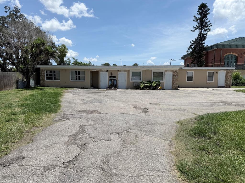 A single-story multi-unit building with a cracked asphalt parking lot in front — 5100 SOUTH ROAD, NEW PORT RICHEY, FL