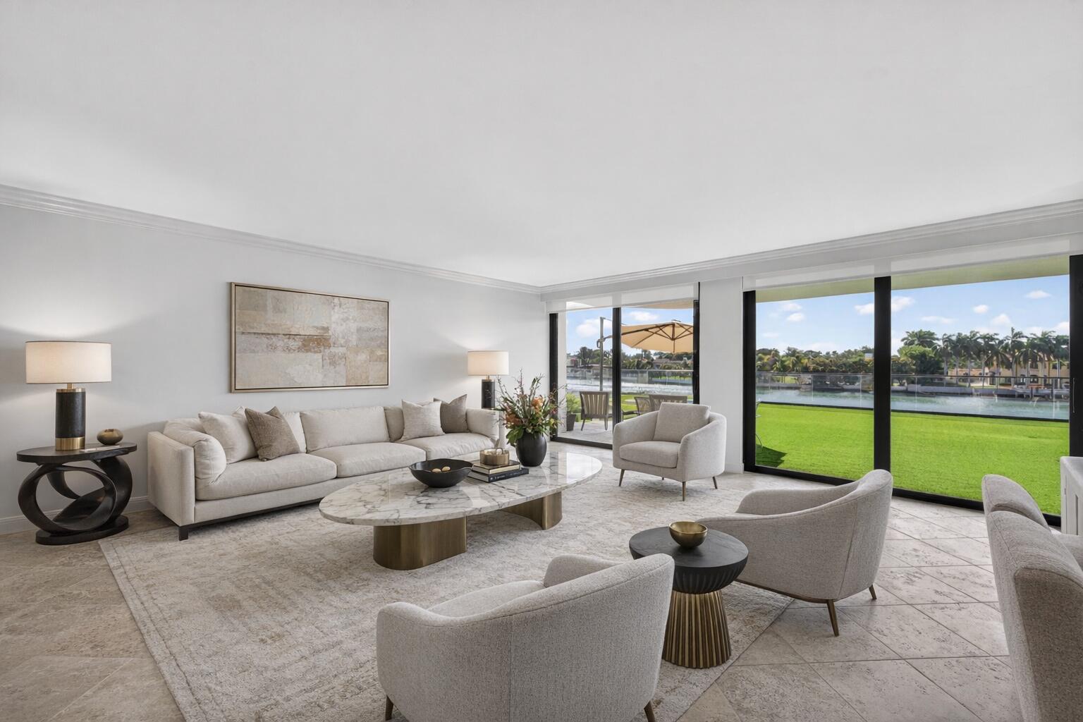 A bright living room features a marble coffee table, neutral seating, and large sliding glass doors — 5500 Collins Avenue # 302, Miami Beach FL 33140, MIAMI BEACH, FL