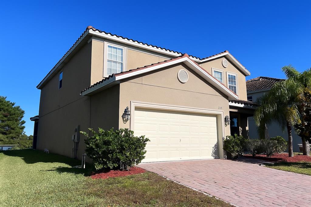 A two-story house with a beige stucco exterior, a tile roof, and a two-car garage — 2037 LAKE SIDE AVENUE, DAVENPORT, FL