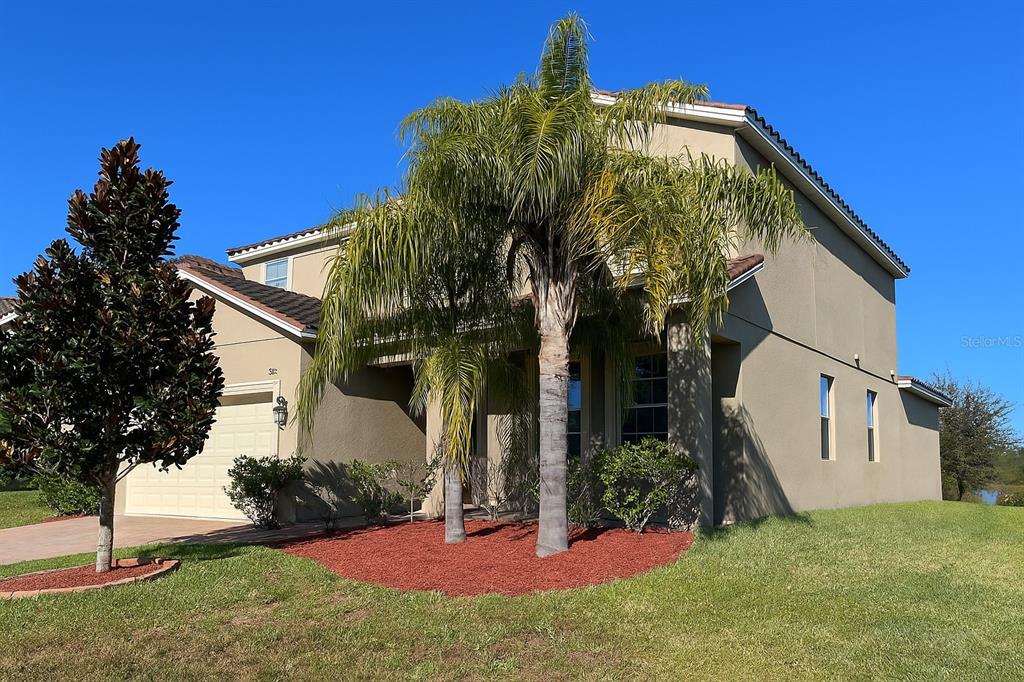 A two-story stucco house with a palm tree in the front yard — 2037 LAKE SIDE AVENUE, DAVENPORT, FL