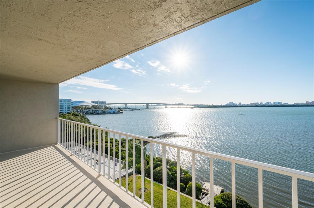 A balcony with a white railing overlooks a bay, a bridge, and a distant city skyline — 500 N OSCEOLA AVENUE UNIT 307, CLEARWATER, FL