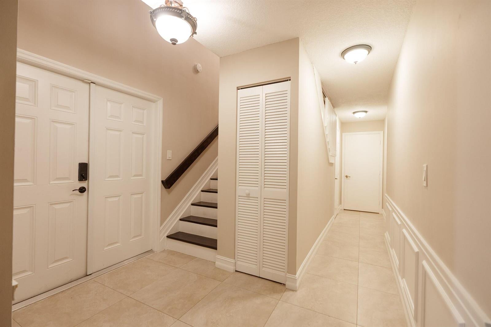 An entryway features tiled floors, a staircase with dark treads, and white louvered closet doors — 7251 NW 24th Court, Margate FL 33063, MARGATE, FL