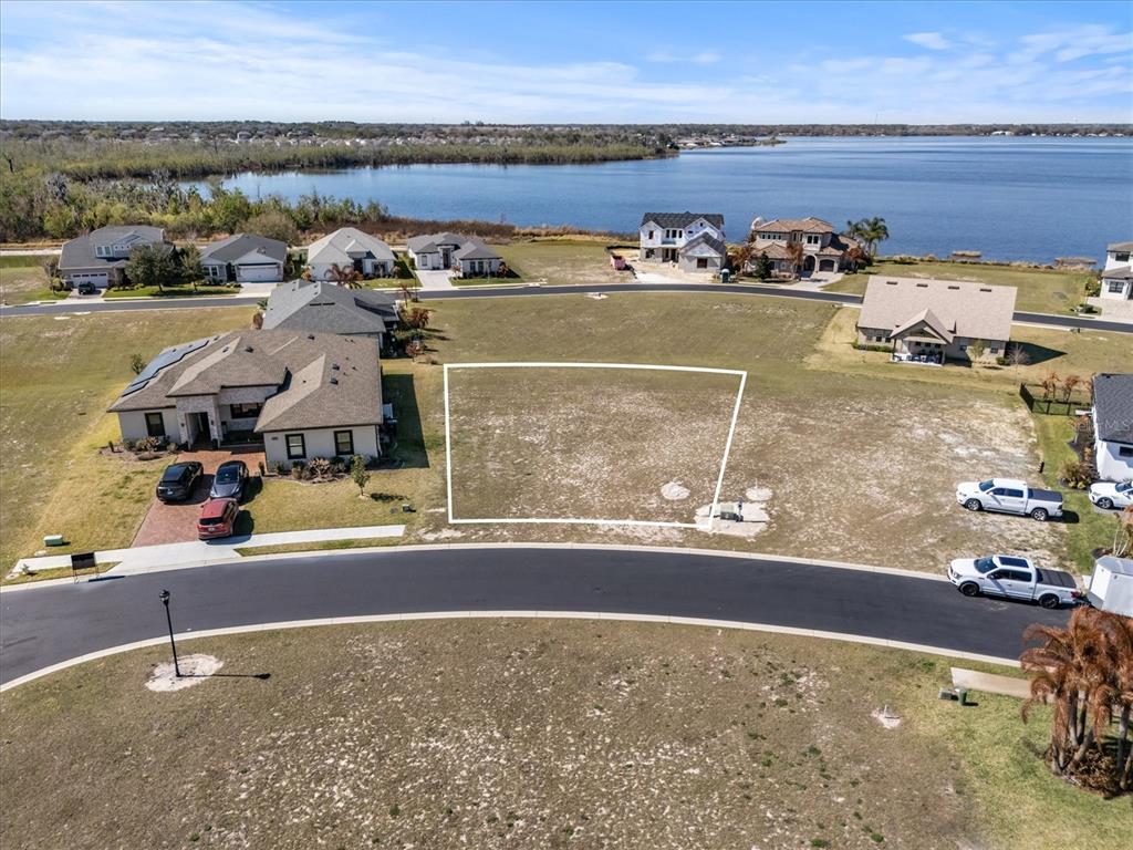 An aerial view shows a vacant residential lot outlined in white within a suburban neighborhood — 473 WATERFERN TRAIL DRIVE, AUBURNDALE, FL