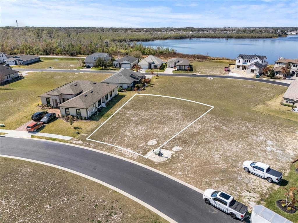 An aerial view shows a vacant residential lot outlined in white within a suburban neighborhood — 473 WATERFERN TRAIL DRIVE, AUBURNDALE, FL