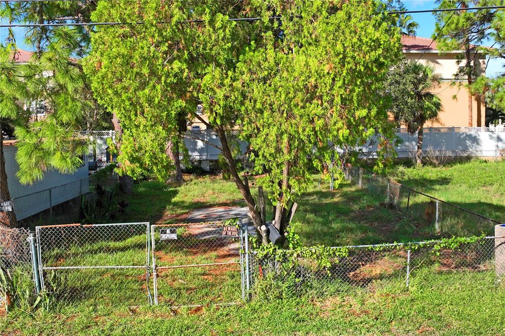 A fenced, grassy lot with a large tree and a concrete pad sits behind a gate — 5635 VAN DOREN AVE, NEW PORT RICHEY, FL