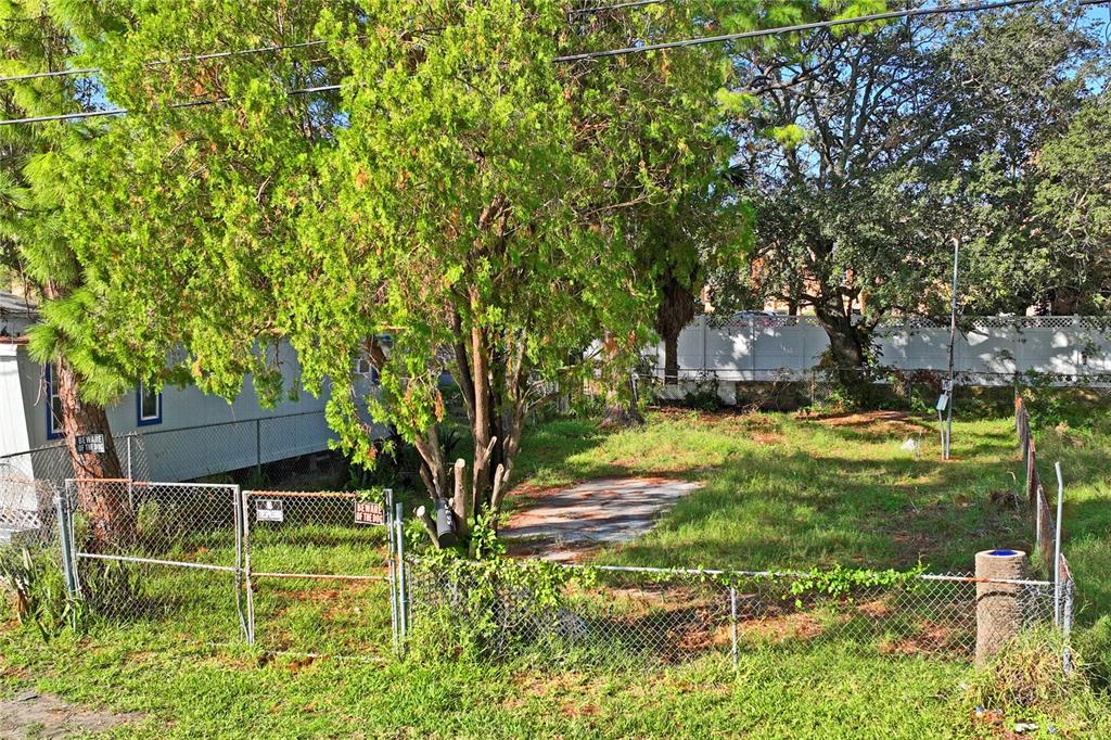 A fenced, grassy vacant lot features a concrete pad and several mature trees — 5635 VAN DOREN AVE, NEW PORT RICHEY, FL