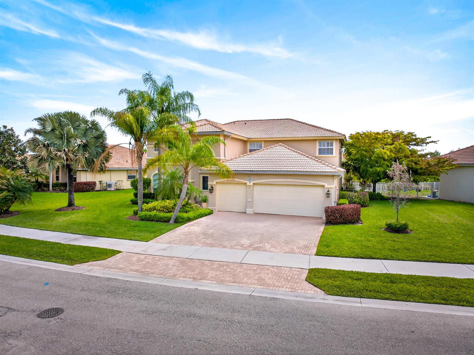 A two-story suburban house features a tiled roof, a paved driveway, and a manicured lawn — 1315 SE Conference Circle, Stuart FL 34997, STUART, FL