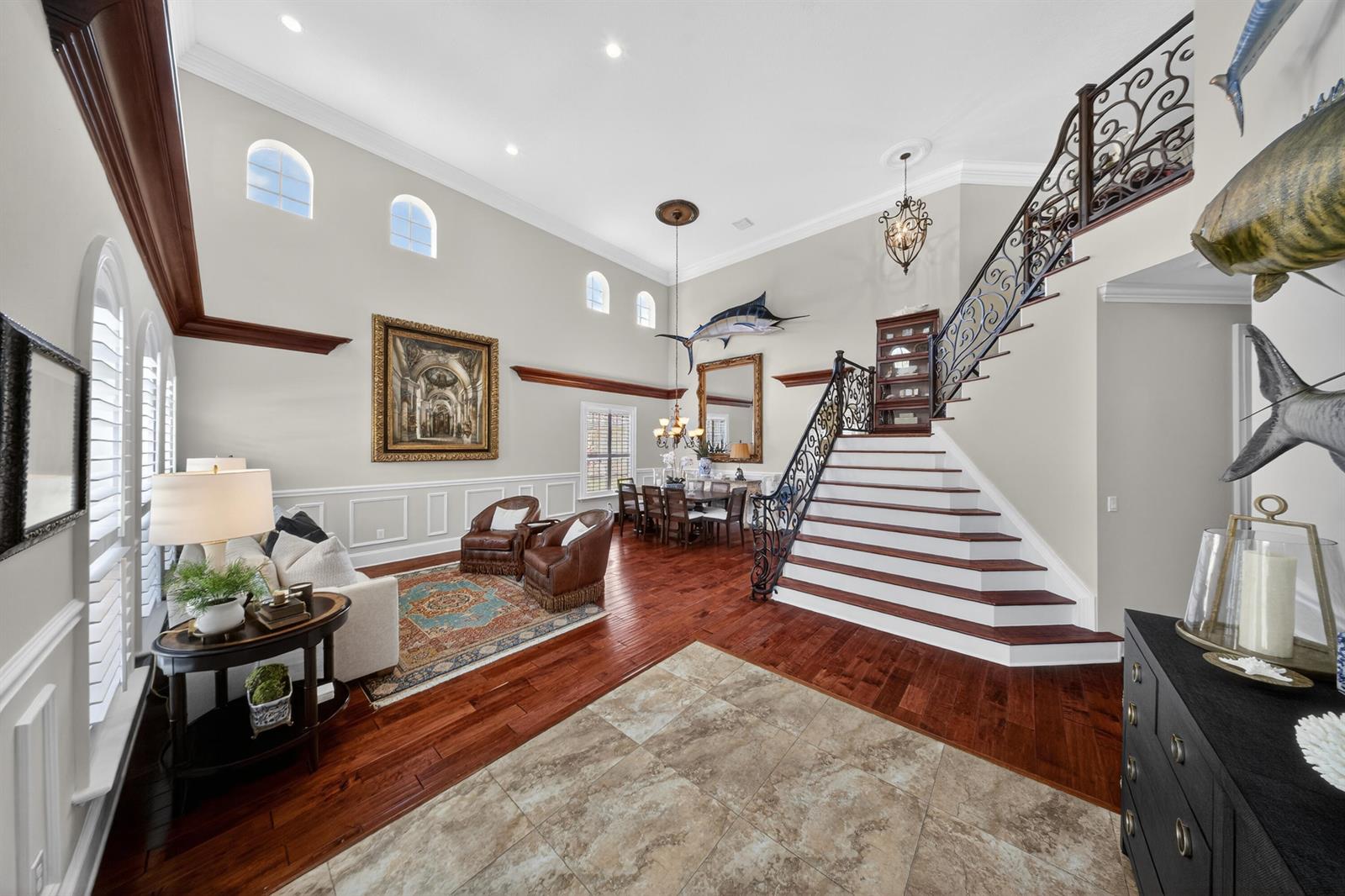 A grand foyer features a sweeping staircase, hardwood floors, high ceilings, and a dining area — 1315 SE Conference Circle, Stuart FL 34997, STUART, FL