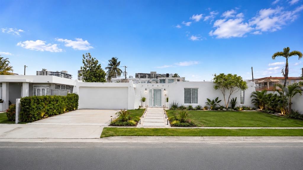 A white single-story house with a garage, a paved walkway, and a manicured front lawn — 2 CALLE MAR DE IRLANDA, CAROLINA, PR