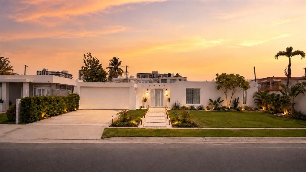 A single-story white house with a garage and a paved walkway at sunset — 2 CALLE MAR DE IRLANDA, CAROLINA, PR
