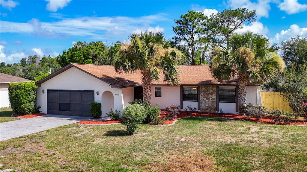 A single-story house with a garage, palm trees, and a stone facade exterior — 4435 BAYRIDGE COURT, SPRING HILL, FL