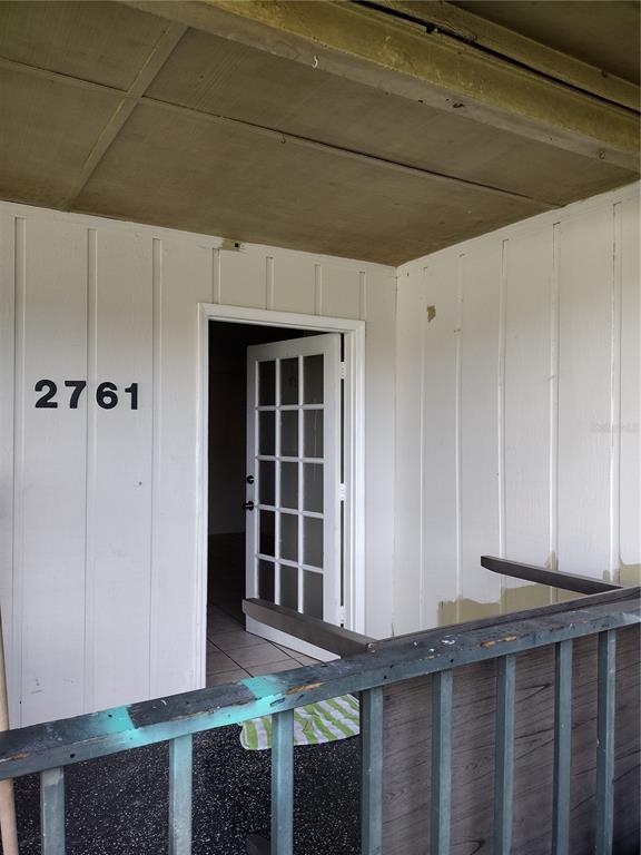 A white exterior wall with the number 2761, a glass-paneled door, and a metal railing — 2761 MICHIGAN AVENUE, KISSIMMEE, FL