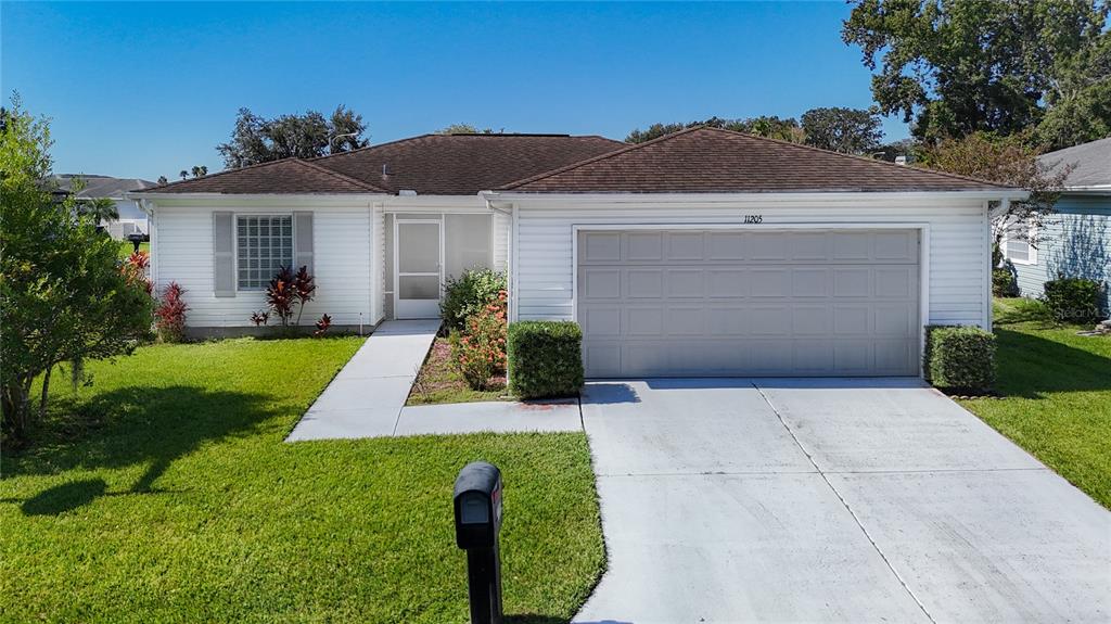 A single-story white house with a two-car garage and a front walkway — 11205 COREY PAVIN LANE, SAN ANTONIO, FL