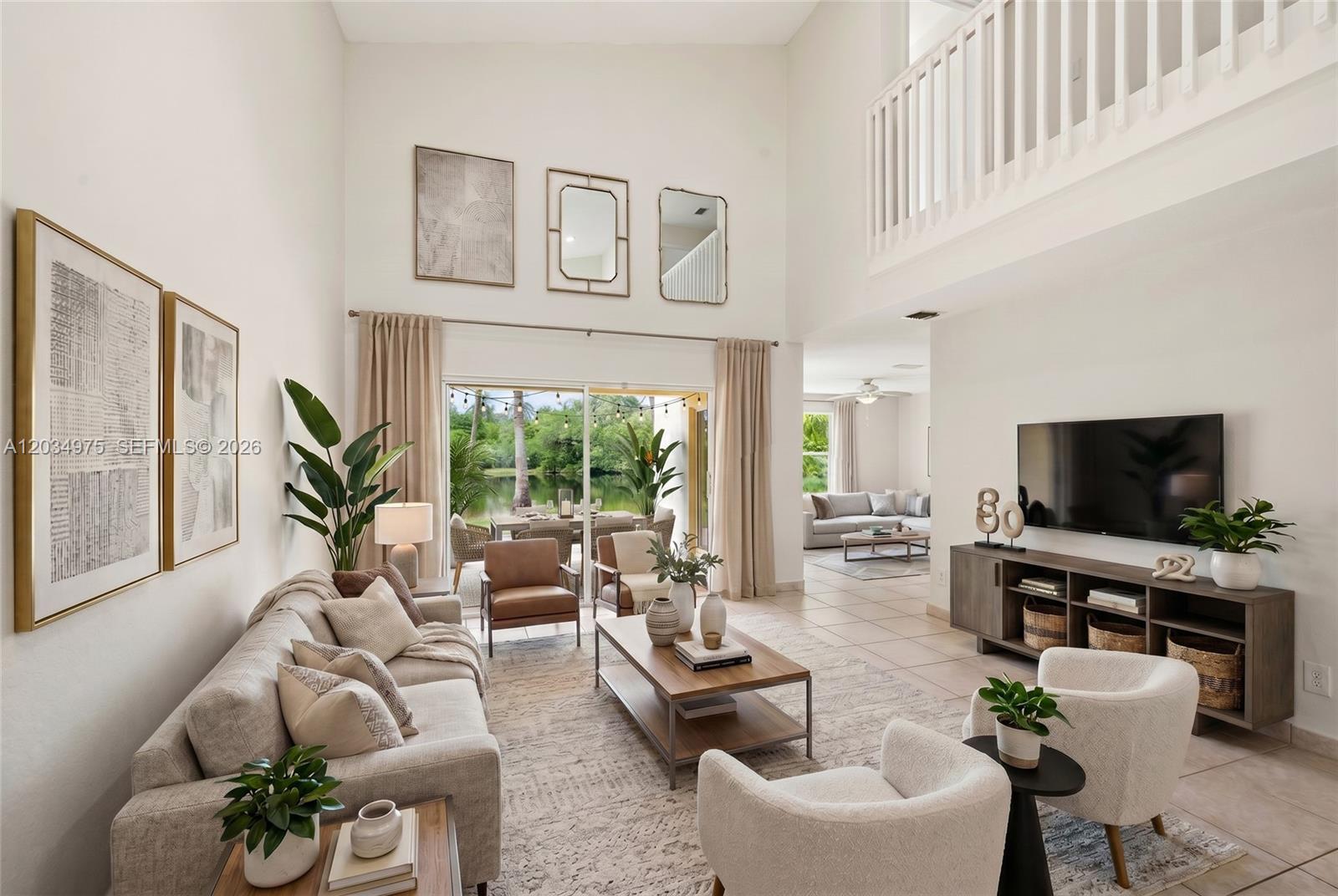 A bright, high-ceilinged living room features a sofa, armchairs, a coffee table, and a television — 17908 SW 30th Ct, Miramar FL 33029, MIRAMAR, FL