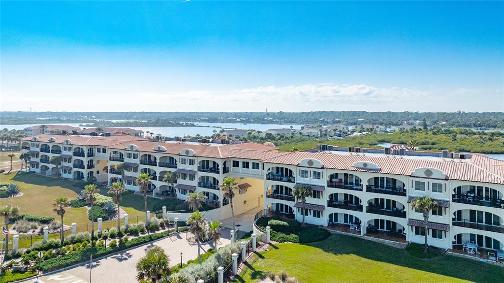 An aerial view of a multi-story residential building with arched balconies and a tiled roof — 2450 N OCEAN SHORE BOULEVARD UNIT 115, FLAGLER BEACH, FL